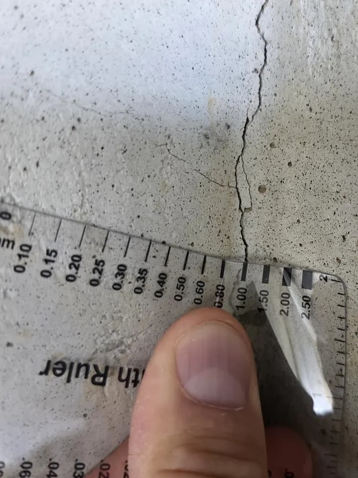 Fissure verticale mesurée au fissuromètre sur un mur de fondation en béton